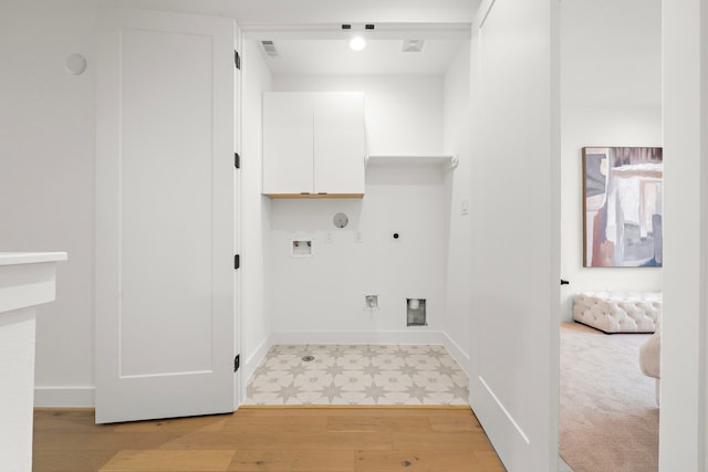 laundry area featuring cabinets, light wood-type flooring, hookup for a washing machine, electric dryer hookup, and hookup for a gas dryer