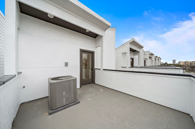 view of patio with cooling unit and a balcony