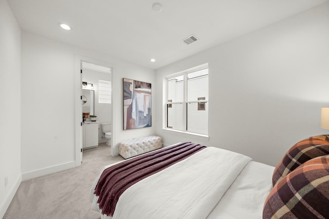 carpeted bedroom featuring ensuite bath