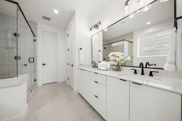 bathroom featuring vanity and a shower with door