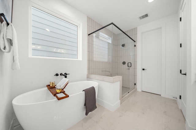 bathroom featuring a wealth of natural light and independent shower and bath