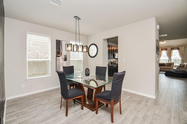 dining room with a chandelier and light hardwood / wood-style flooring