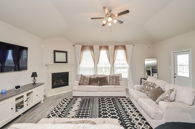 living room with vaulted ceiling, plenty of natural light, and light hardwood / wood-style floors