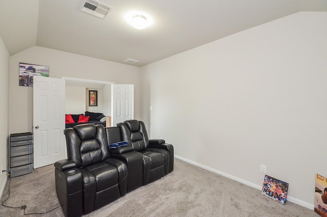 cinema room with lofted ceiling and light carpet