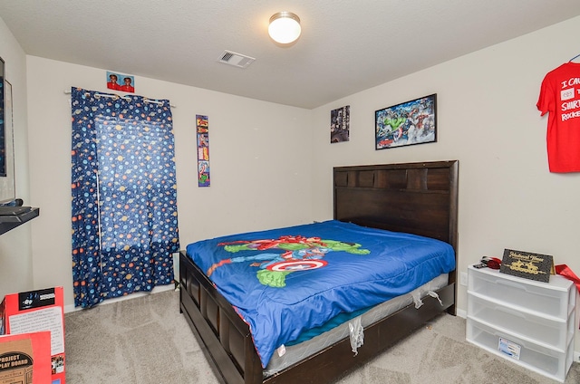 bedroom featuring light carpet and a textured ceiling