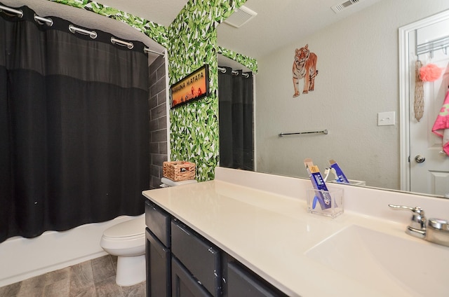 full bathroom with vanity, shower / bath combo with shower curtain, and toilet