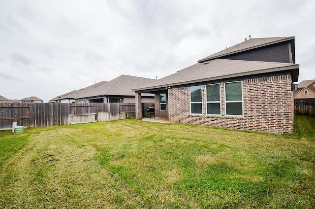 rear view of house featuring a yard and a patio