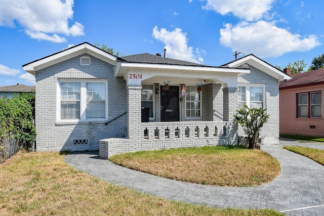 view of front of house with covered porch and a front lawn