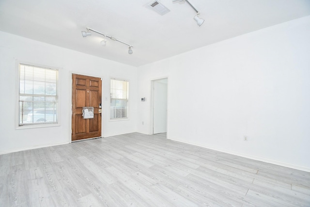 unfurnished room with rail lighting and light hardwood / wood-style floors