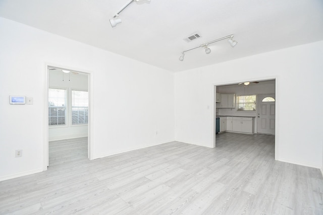 unfurnished living room with light wood-type flooring, track lighting, and ceiling fan