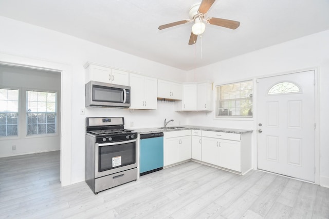 kitchen with white cabinets, stainless steel appliances, and light hardwood / wood-style floors