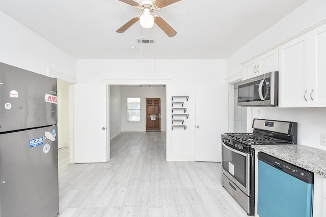 kitchen with ceiling fan, light stone countertops, light wood-type flooring, appliances with stainless steel finishes, and white cabinetry