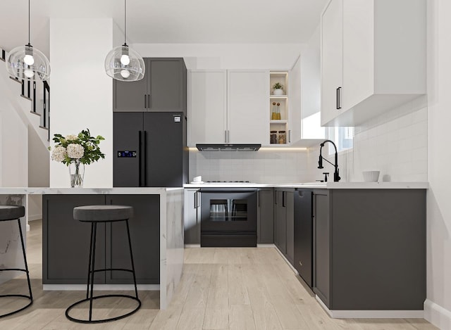 kitchen with white cabinetry, black fridge with ice dispenser, decorative light fixtures, and sink