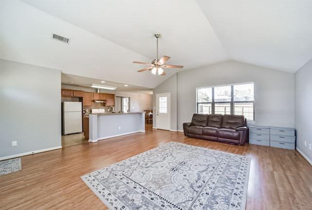 living room featuring vaulted ceiling, light hardwood / wood-style flooring, ceiling fan, and sink