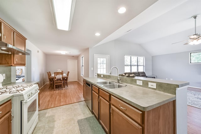 kitchen with lofted ceiling, sink, stainless steel dishwasher, an island with sink, and white range with gas stovetop