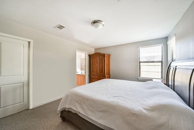 carpeted bedroom featuring ensuite bath