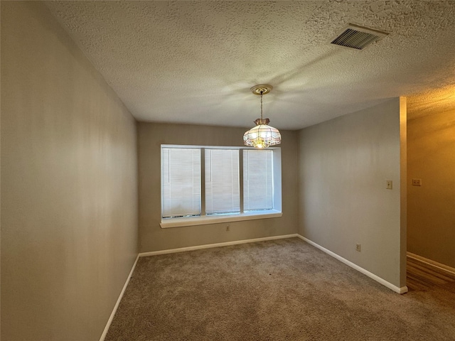 spare room featuring carpet and a textured ceiling