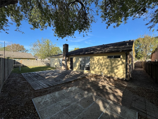 rear view of house with a wooden deck and a yard