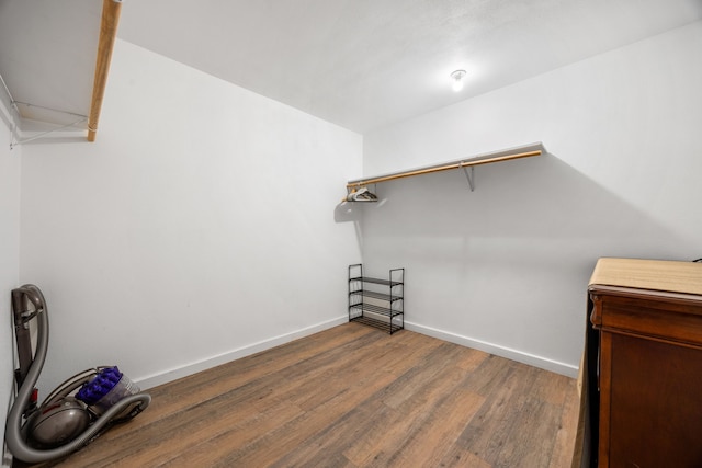 walk in closet with dark hardwood / wood-style flooring