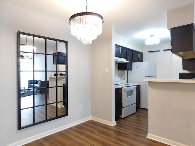 kitchen with dark hardwood / wood-style floors, tasteful backsplash, white appliances, and a chandelier