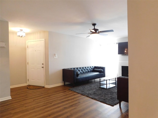 living room with ceiling fan and dark wood-type flooring