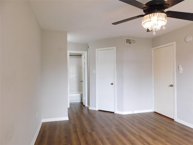 unfurnished bedroom featuring ceiling fan, dark hardwood / wood-style flooring, and ensuite bathroom