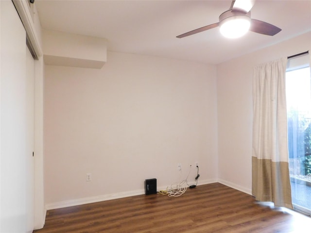 empty room with ceiling fan and dark wood-type flooring