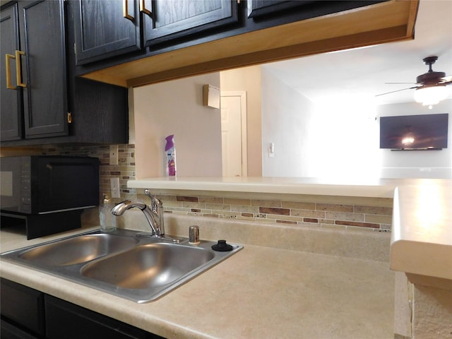 kitchen with backsplash, ceiling fan, and sink