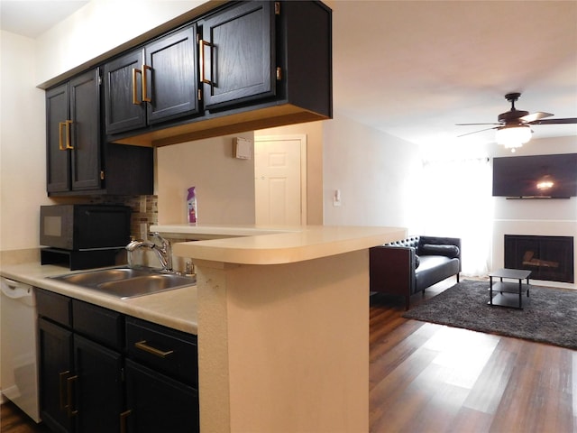 kitchen featuring dishwasher, dark wood-type flooring, sink, ceiling fan, and kitchen peninsula