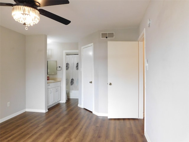 unfurnished bedroom with dark hardwood / wood-style floors, ceiling fan, and ensuite bathroom