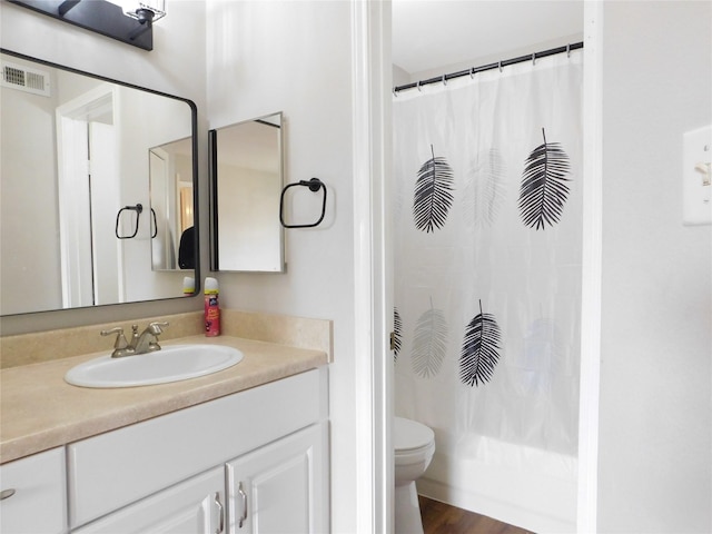 full bathroom with hardwood / wood-style floors, vanity, toilet, and shower / bath combo