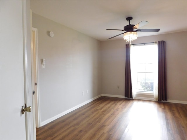 spare room with dark hardwood / wood-style flooring and ceiling fan