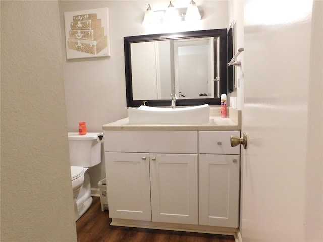 bathroom featuring toilet, vanity, and hardwood / wood-style flooring