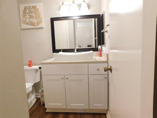 bathroom with hardwood / wood-style floors, vanity, and toilet