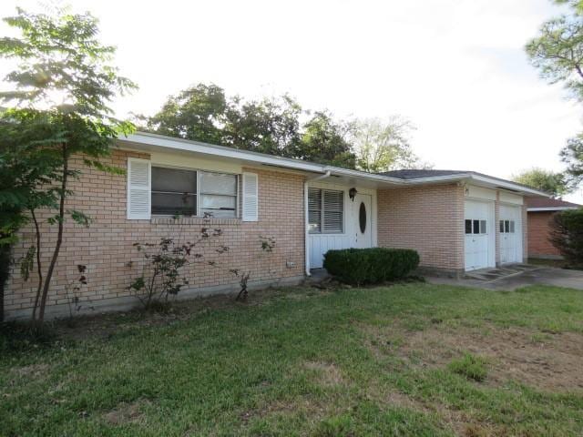 single story home with a front yard and a garage