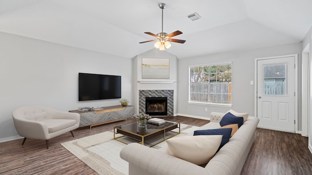 living room featuring ceiling fan, dark hardwood / wood-style flooring, lofted ceiling, and a tiled fireplace