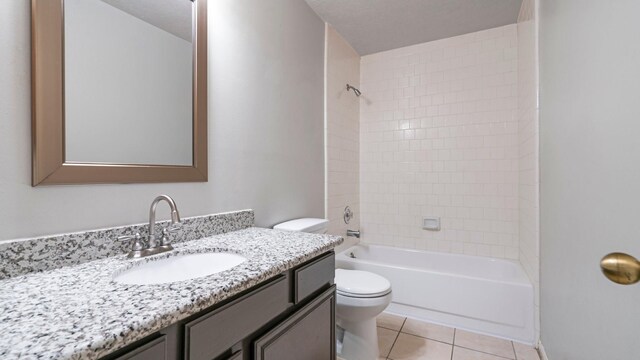 full bathroom featuring tile patterned floors, tiled shower / bath combo, toilet, and vanity