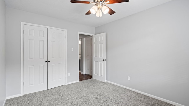 unfurnished bedroom featuring a closet, ceiling fan, and dark colored carpet