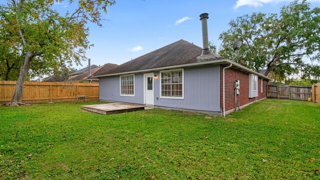 back of property with a lawn and a deck