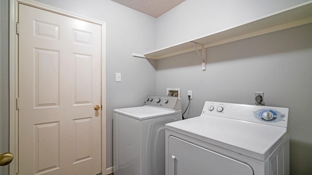 clothes washing area featuring a textured ceiling and washing machine and dryer