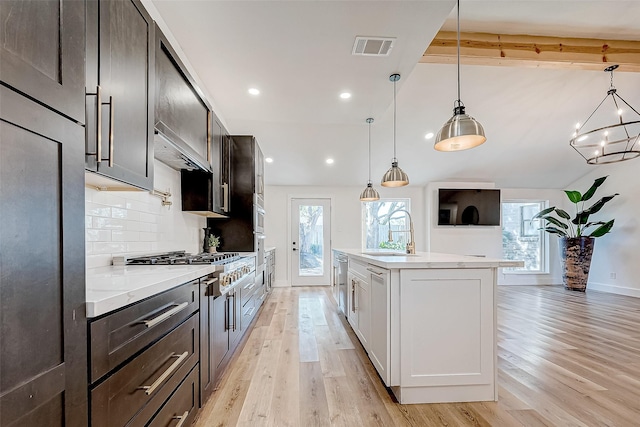 kitchen with light hardwood / wood-style flooring, hanging light fixtures, and sink