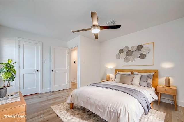 bedroom with ceiling fan and light hardwood / wood-style floors