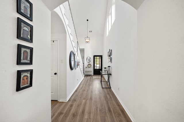 corridor featuring light hardwood / wood-style floors and high vaulted ceiling