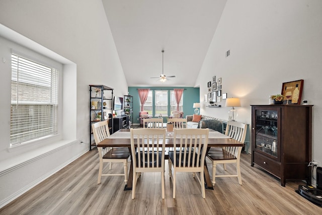 dining area featuring light hardwood / wood-style floors, high vaulted ceiling, and ceiling fan