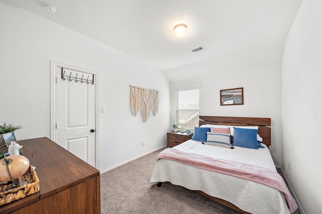 carpeted bedroom featuring a textured ceiling and vaulted ceiling