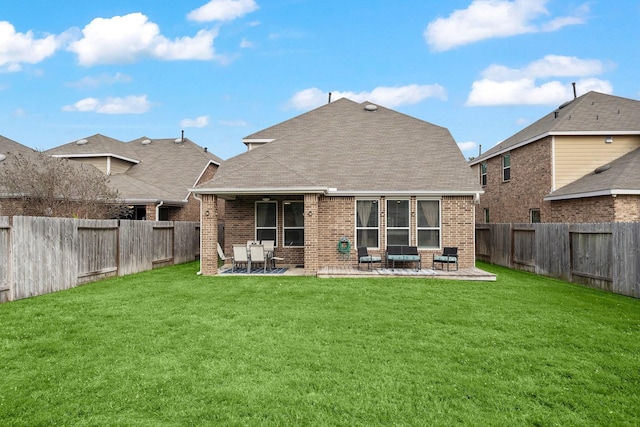 rear view of house featuring a yard and a patio area