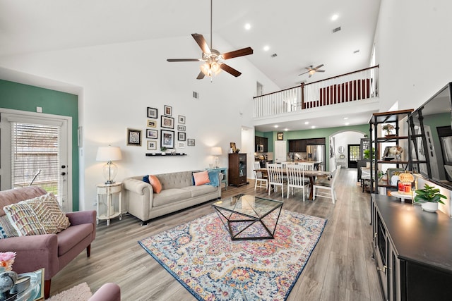 living room featuring ceiling fan, high vaulted ceiling, and hardwood / wood-style flooring