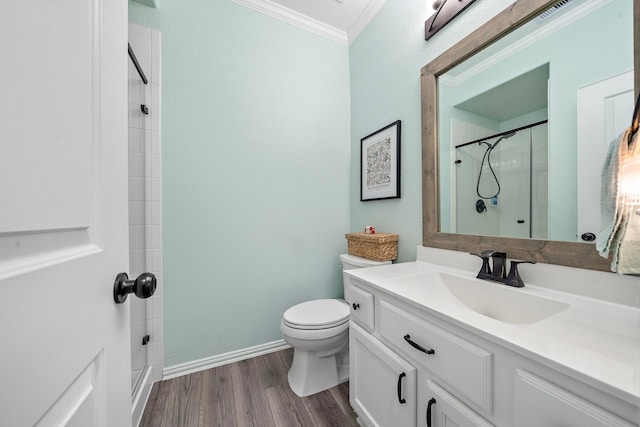 bathroom featuring vanity, a shower, toilet, ornamental molding, and wood-type flooring