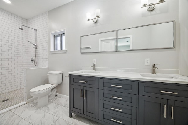 bathroom with toilet, vanity, and tiled shower