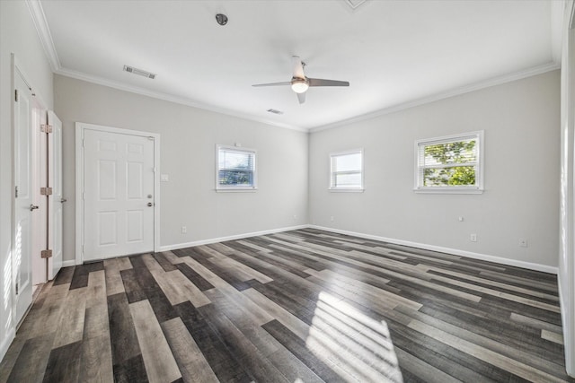 empty room with crown molding, dark wood-type flooring, and a healthy amount of sunlight